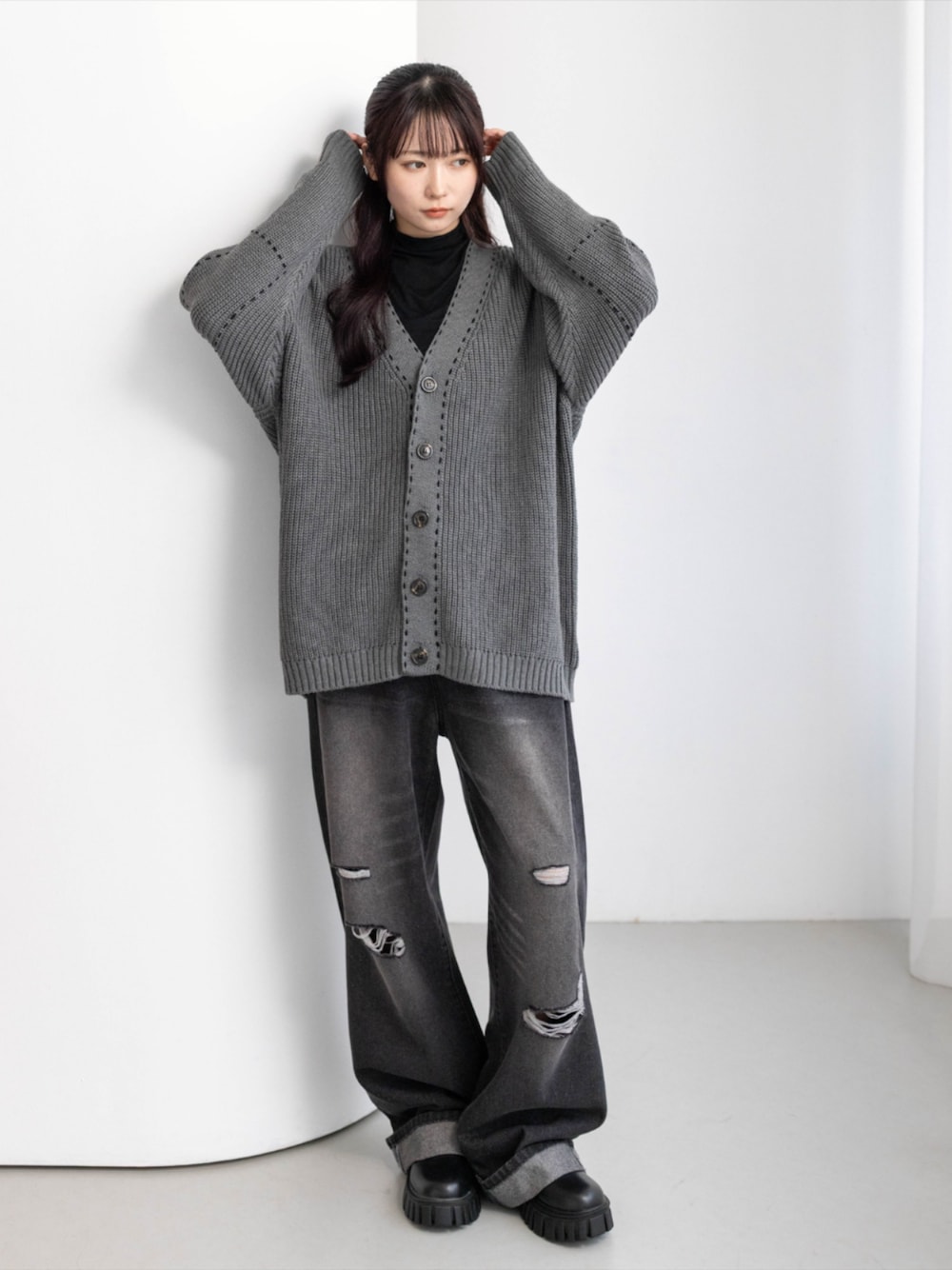 ブラック系のTシャツ/カットソー、ブラック系のデニムパンツ、ブラック系のブーツを着用したレディースの秋コーディネートの1枚目の写真