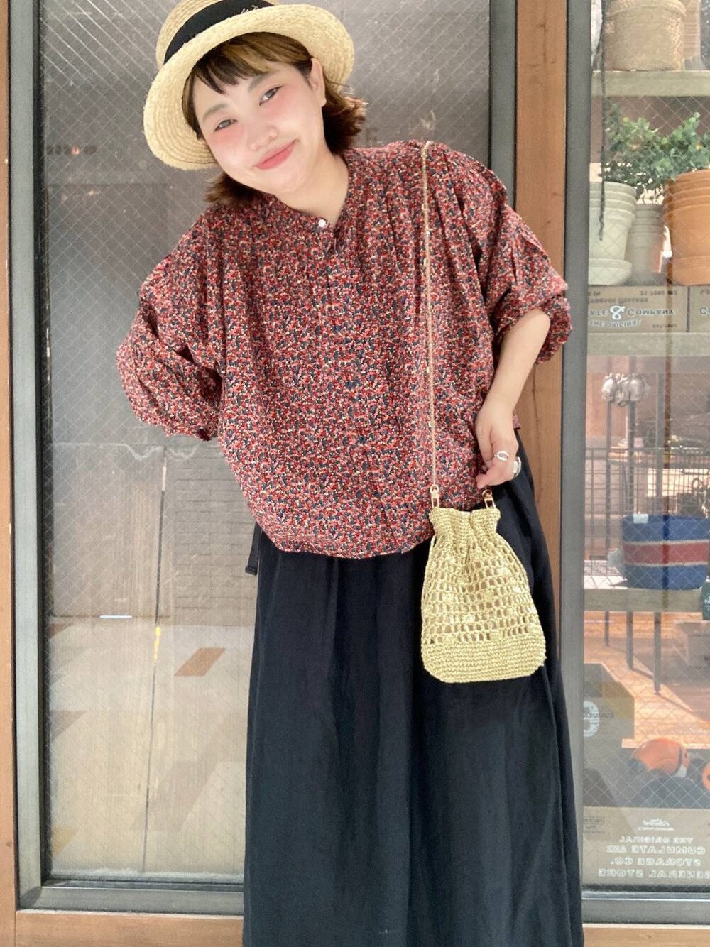 イエロー系のショルダーバッグ、レッド系のシャツ/ブラウス、ブラック系のスカートを着用したレディースの夏コーディネートの1枚目の写真