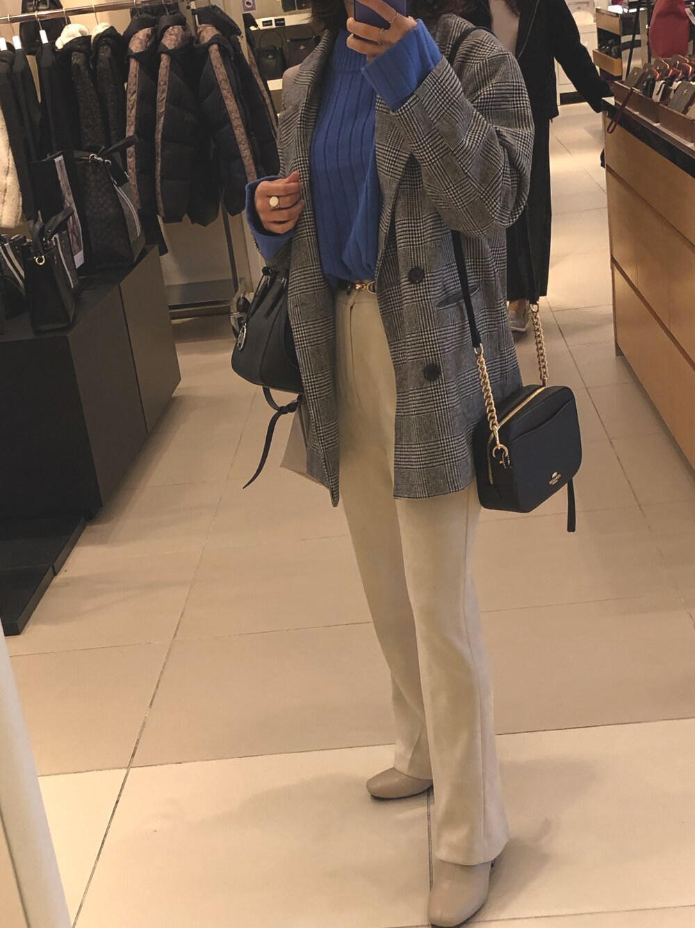 ブラック系のショルダーバッグ、ベージュ系のブーツ、ホワイト系のその他パンツを着用したレディースの秋コーディネートの1枚目の写真