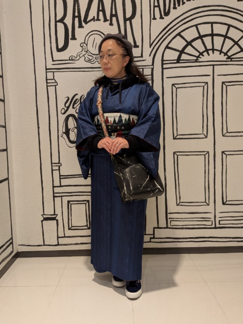 ブラック系のショルダーバッグ、ブルー系のスニーカー、グリーン系の着物を着用したレディースの秋コーディネートの1枚目の写真