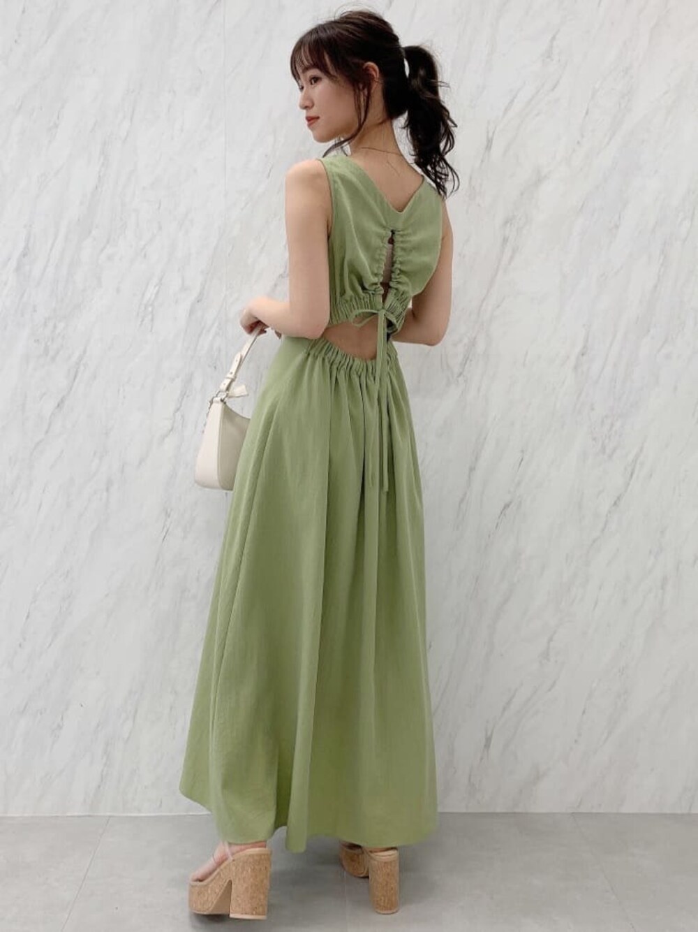 グリーン系のワンピース、その他のサンダルを着用したレディースの春コーディネートの1枚目の写真