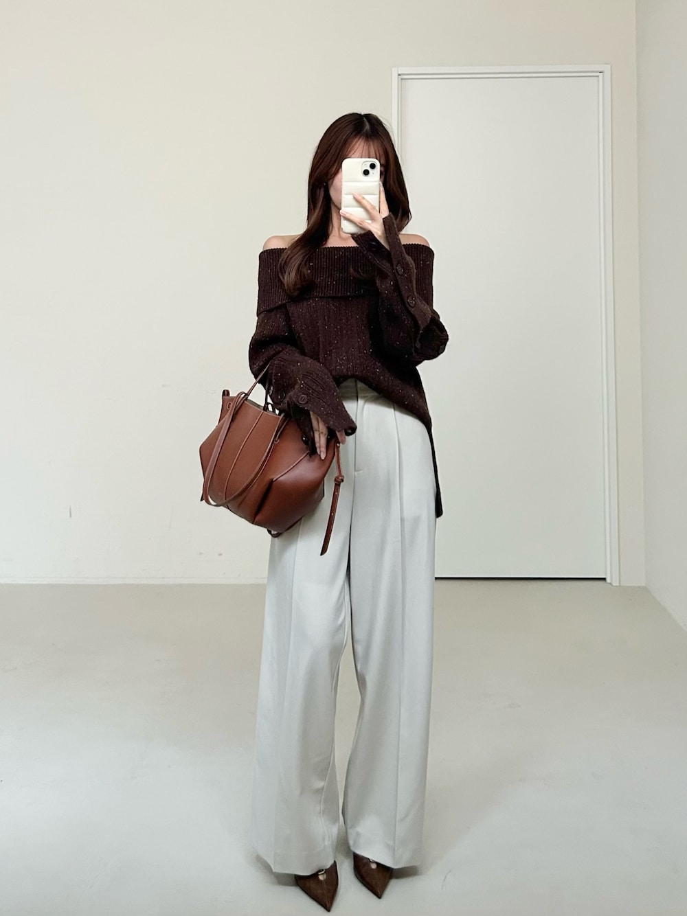 ブラウン系のニット/セーター、ホワイト系のスラックスを着用したレディースの秋コーディネートの1枚目の写真