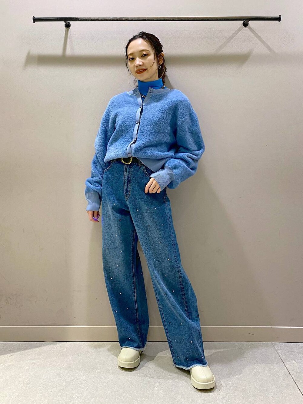 ブルー系のニット/セーター、ホワイト系のブーツ、ブルー系のワンピースを着用したレディースの冬コーディネートの1枚目の写真