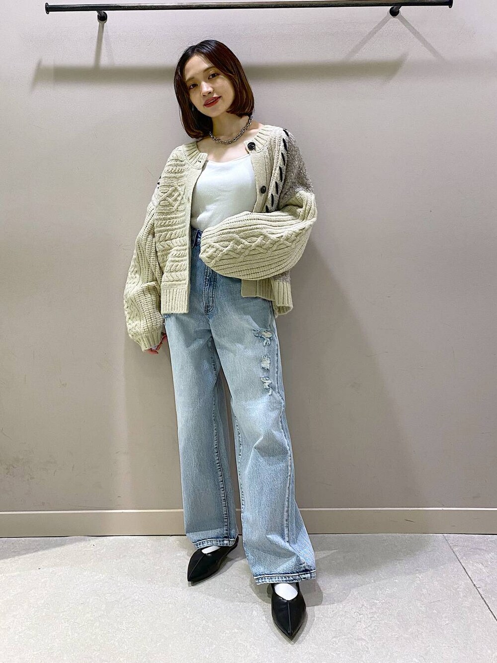 ホワイト系のキャミソール、ブルー系のデニムパンツ、ブラック系のパンプスを着用したレディースの秋コーディネートの1枚目の写真