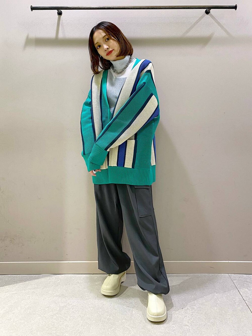 グリーン系のニット/セーター、ホワイト系のブーツ、シルバー系のTシャツ/カットソーを着用したレディースの秋コーディネートの1枚目の写真