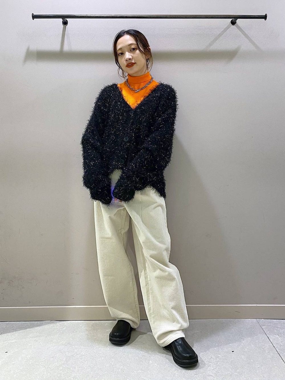 オレンジ系のニット/セーター、ブラック系のブーツ、ホワイト系のその他パンツを着用したレディースの秋コーディネートの1枚目の写真