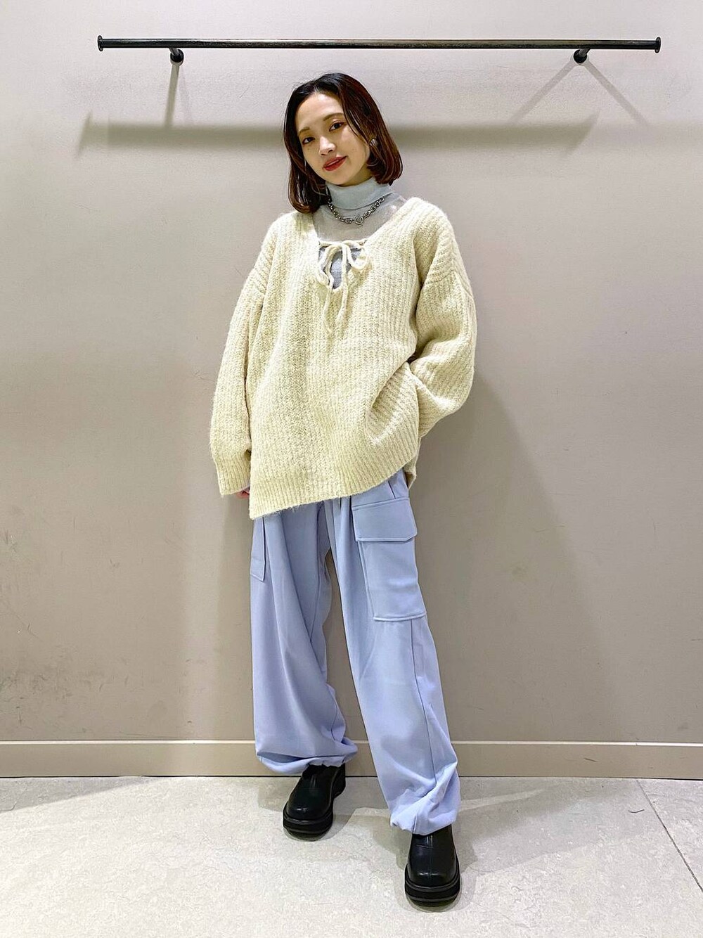 ホワイト系のニット/セーター、ブラック系のブーツ、シルバー系のTシャツ/カットソーを着用したレディースの秋コーディネートの1枚目の写真