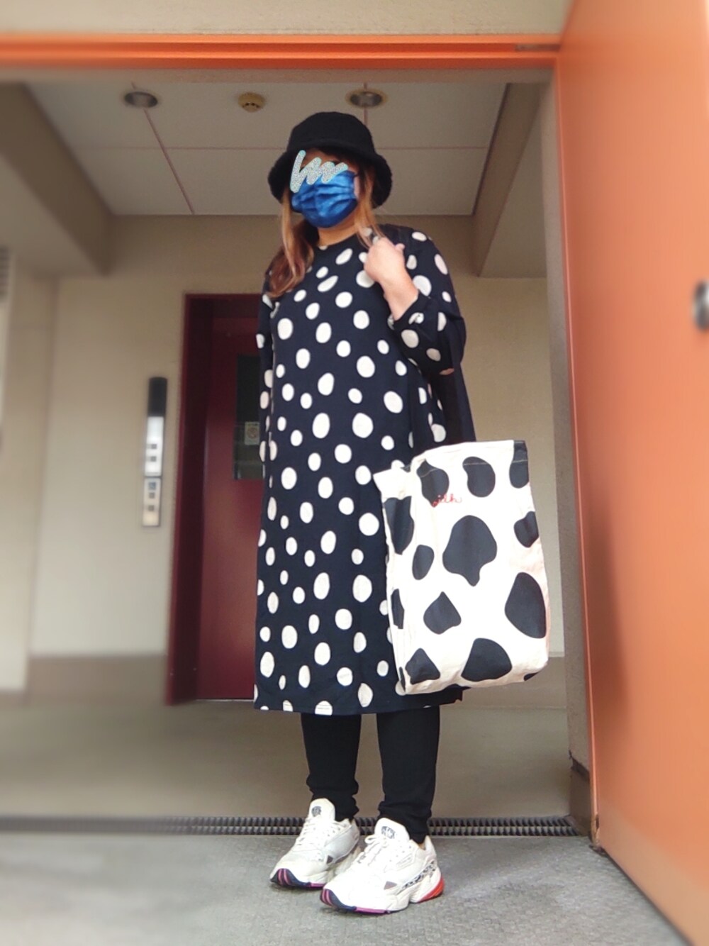 ブラック系のワンピース、ブラック系のトートバッグ、ホワイト系のスニーカーを着用したレディースの秋コーディネートの1枚目の写真