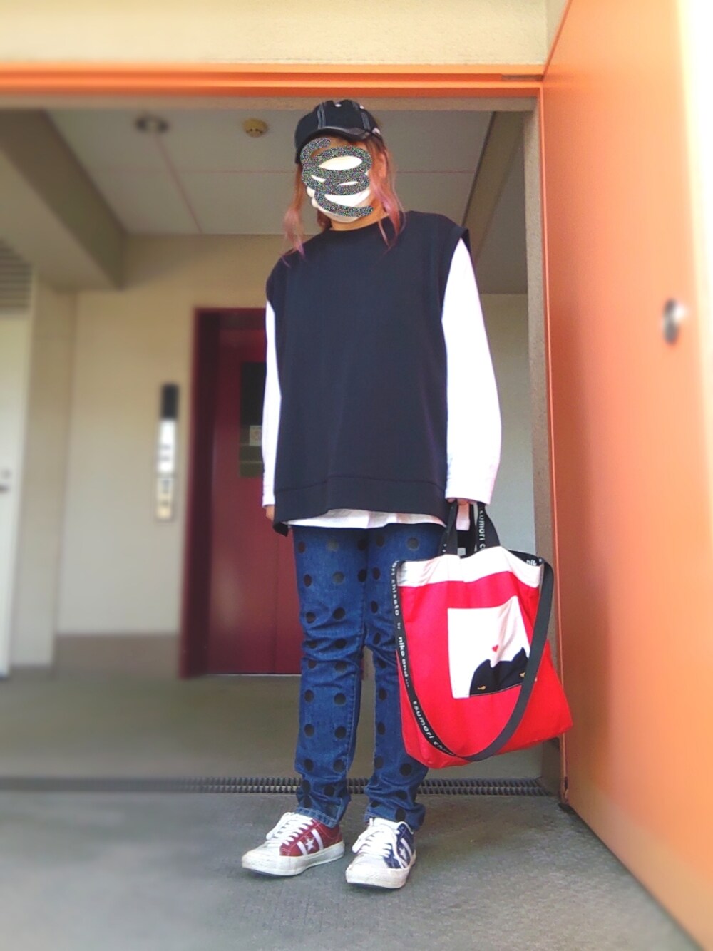 ブラック系のベスト、ホワイト系のTシャツ/カットソー、ブルー系のデニムパンツを着用したレディースの秋コーディネートの1枚目の写真