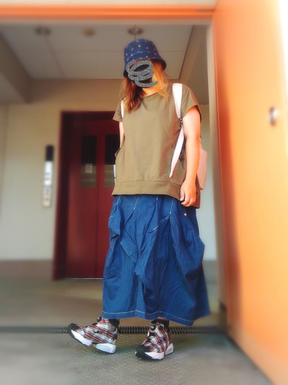 グリーン系のTシャツ/カットソー、ブルー系のデニムスカート、ホワイト系のバックパック/リュックを着用したレディースの秋コーディネートの1枚目の写真