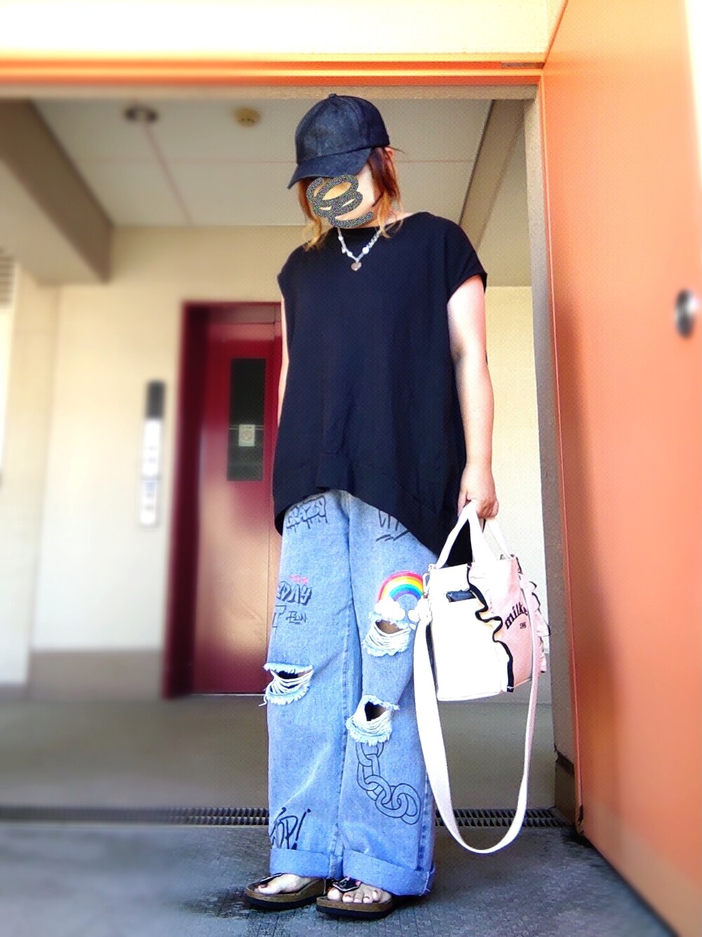 ブラック系のTシャツ/カットソー、ブルー系のデニムパンツ、ホワイト系のショルダーバッグを着用したレディースの秋コーディネートの1枚目の写真