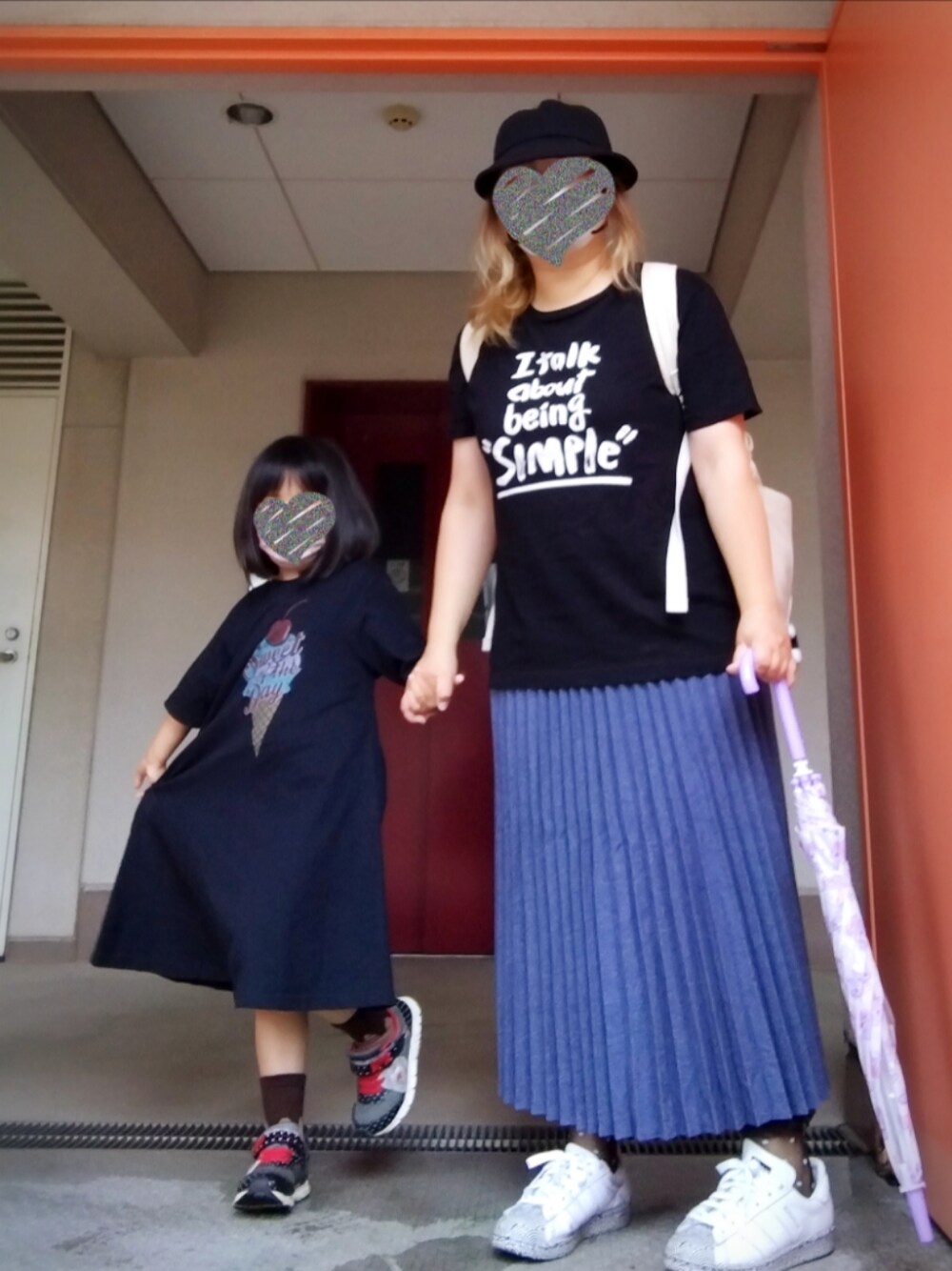 ブラック系のTシャツ/カットソー、ブルー系のスカート、ホワイト系のスニーカーを着用したレディースの夏コーディネートの1枚目の写真