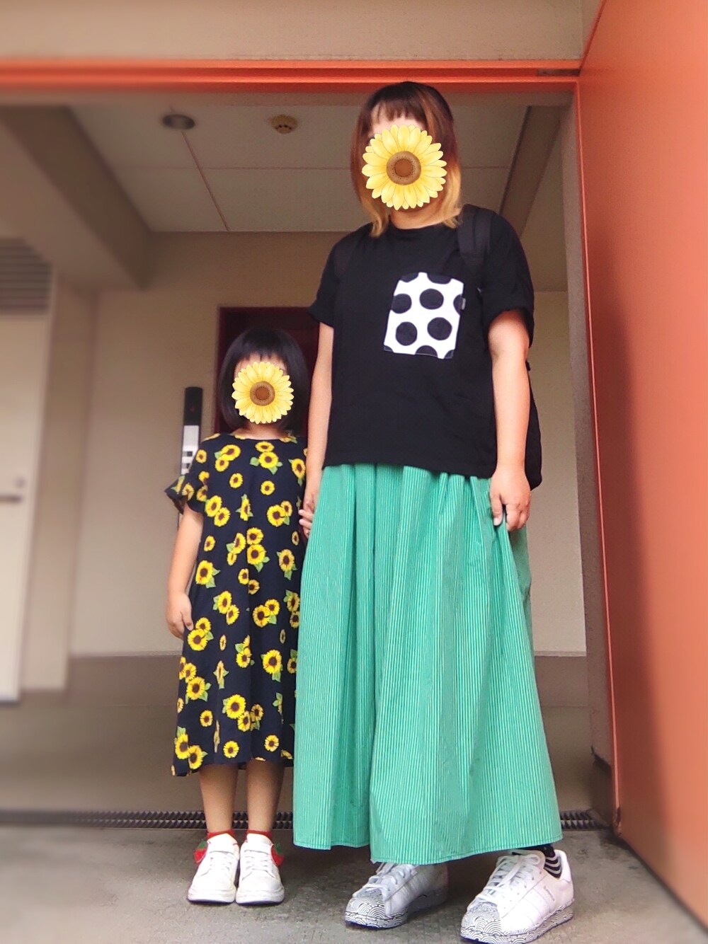 ブラック系のTシャツ/カットソー、グリーン系のスカート、ホワイト系のスニーカーを着用したレディースの夏コーディネートの1枚目の写真