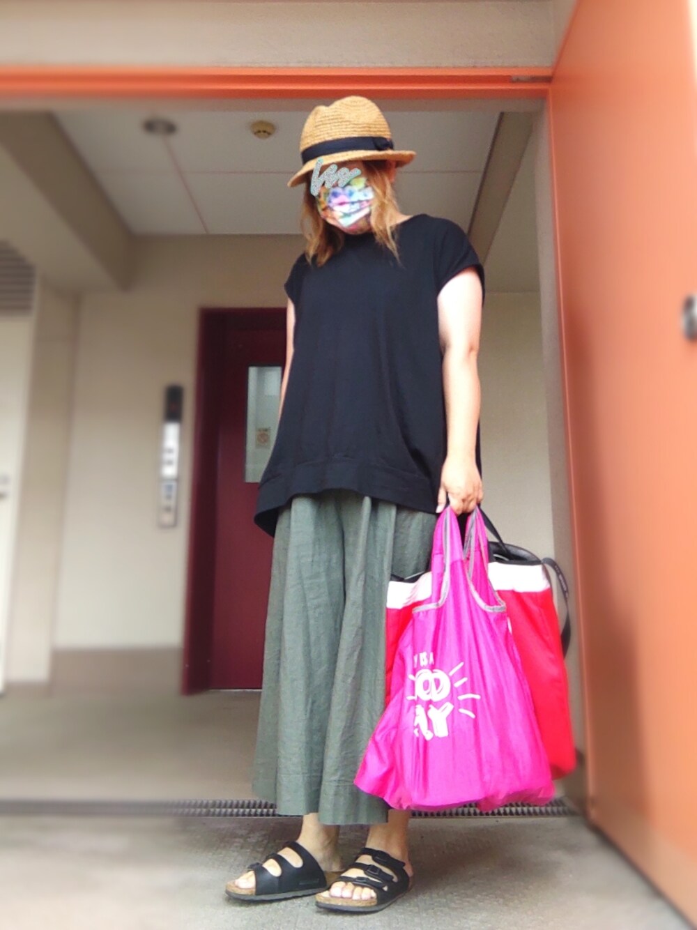 ブラック系のTシャツ/カットソー、ピンク系のエコバッグ/サブバッグ、ブラック系のサンダルを着用したレディースの秋コーディネートの1枚目の写真