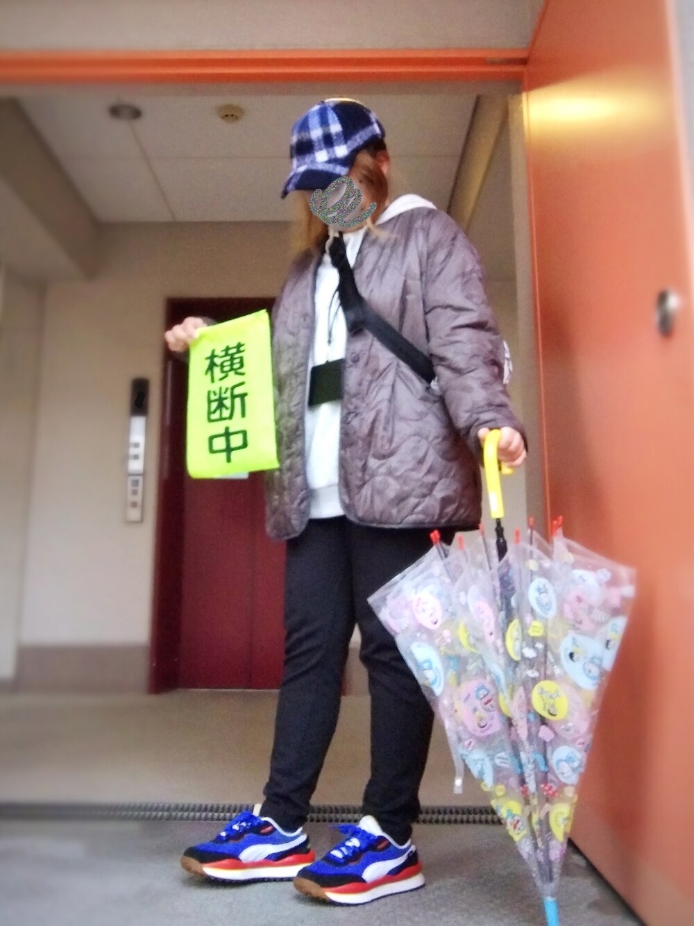 グレー系のミリタリージャケット、ベージュ系のパーカー、ブラック系のパンツを着用したレディースの冬コーディネートの1枚目の写真