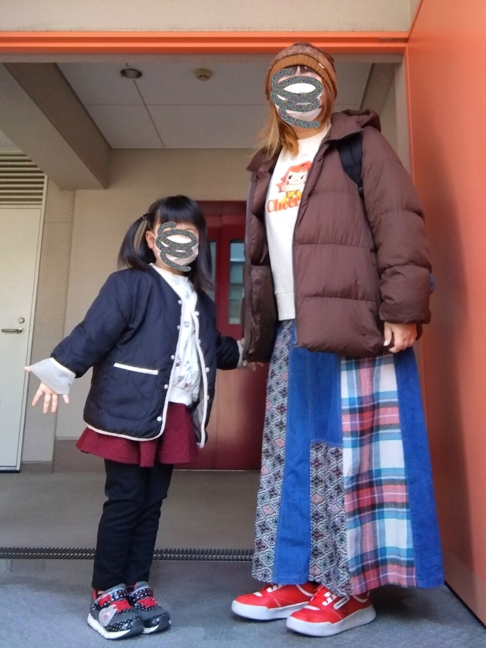 ブラウン系のダウンジャケット/コート、ベージュ系のTシャツ/カットソー、ブルー系のスカートを着用したレディースの冬コーディネートの1枚目の写真