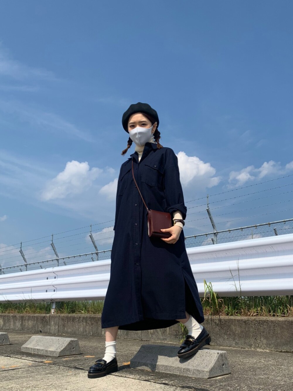 ブラック系のパンプス、ブラウン系のショルダーバッグ、ブルー系のワンピースを着用したレディースの秋コーディネートの1枚目の写真