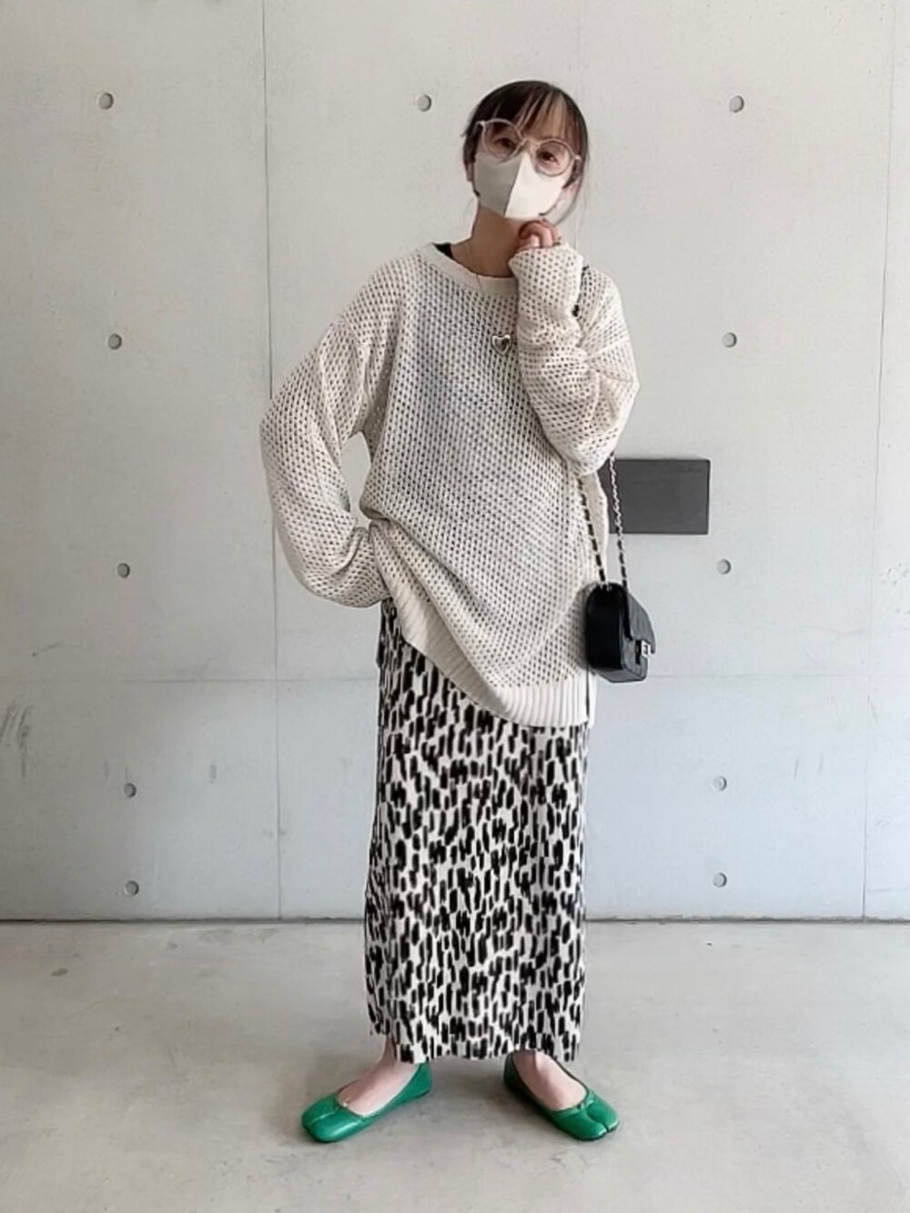 ホワイト系のニット/セーター、ホワイト系のスカート、ブラック系のショルダーバッグを着用したレディースの春コーディネートの1枚目の写真