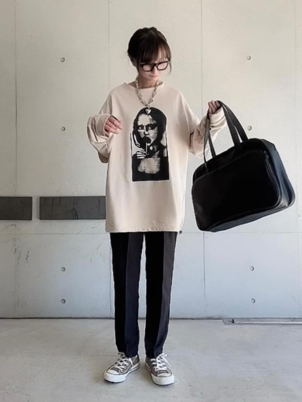 ブラック系のその他パンツ、ブラック系のボストンバッグ、ベージュ系のTシャツ/カットソーを着用したレディースの秋コーディネートの1枚目の写真