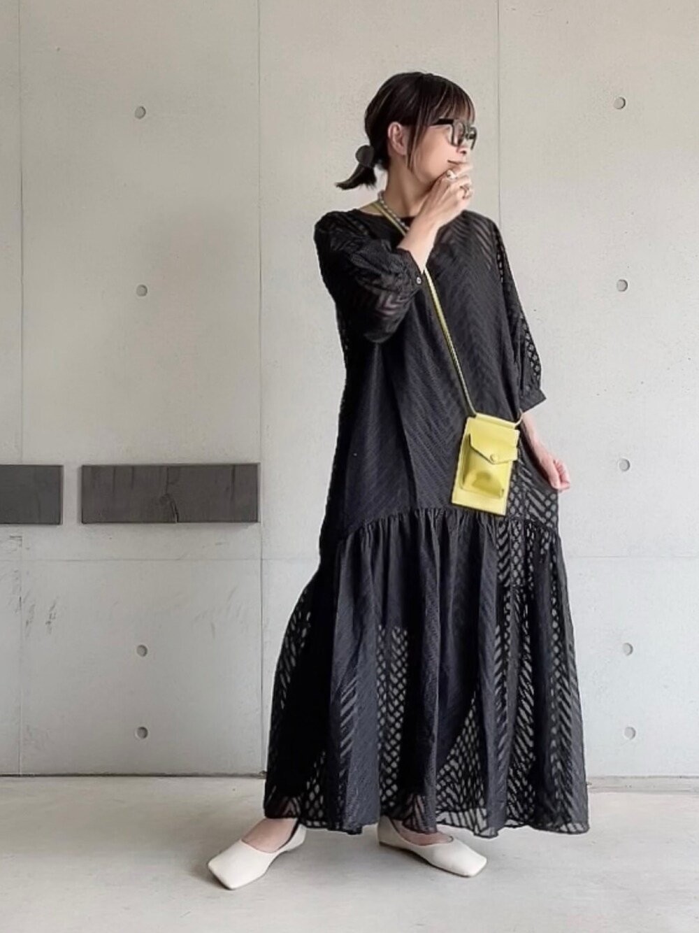 ブラック系のワンピース、グリーン系のショルダーバッグ、ホワイト系のパンプスを着用したレディースの夏コーディネートの1枚目の写真