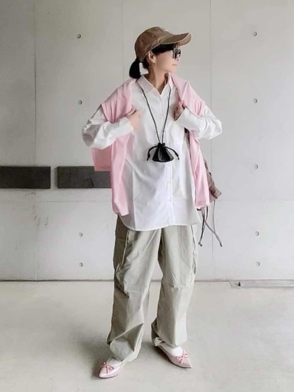 ピンク系のTシャツ/カットソー、ホワイト系のシャツ/ブラウス、グリーン系のカーゴパンツを着用したレディースの冬コーディネートの1枚目の写真