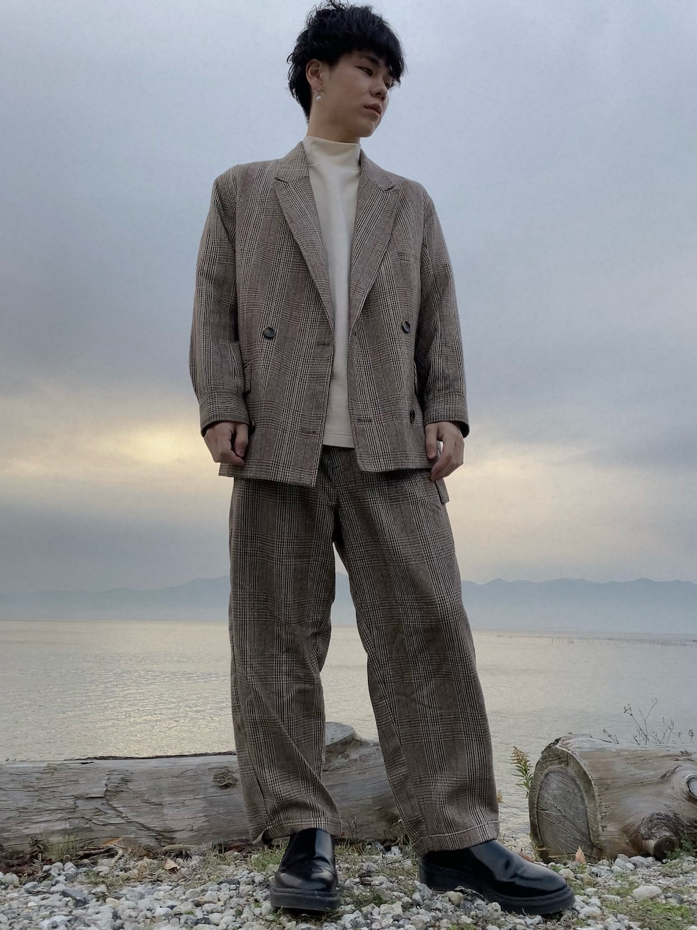 ブラウン系のスラックス、ブラウン系のテーラードジャケット、ブラック系のローファーを着用したメンズの冬コーディネートの1枚目の写真