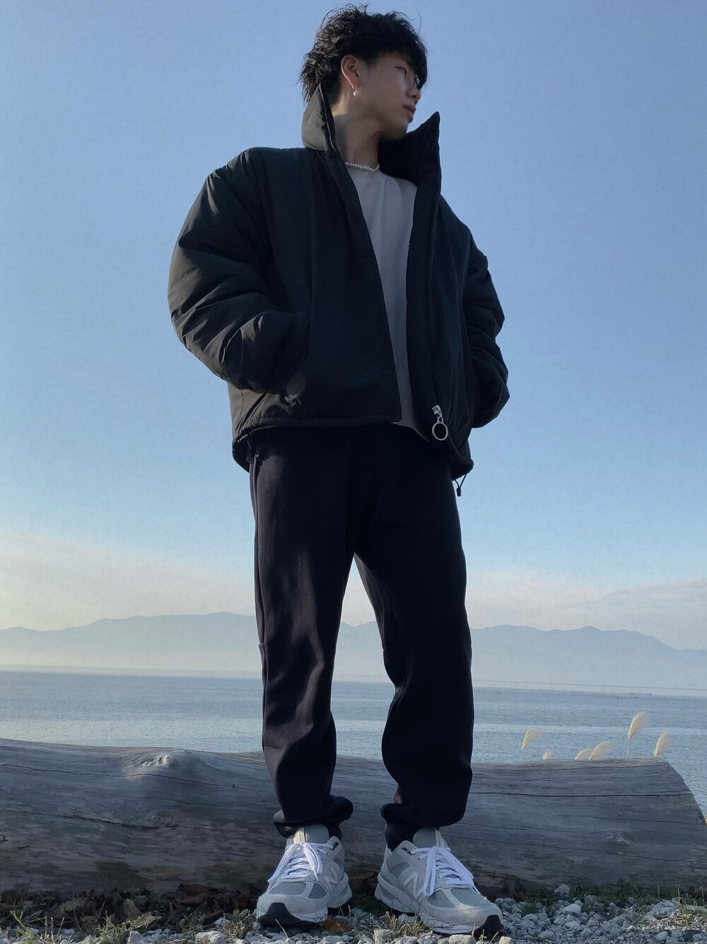 グレー系のスニーカー、ブラック系のスウェットパンツ、ブラック系のダウンジャケット/コートを着用したメンズの冬コーディネートの1枚目の写真