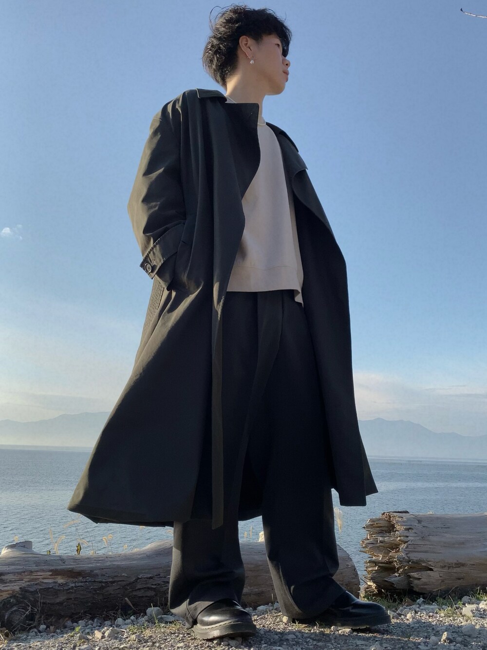 ベージュ系のスウェット、ブラック系のローファー、グレー系のスラックスを着用したメンズの冬コーディネートの1枚目の写真