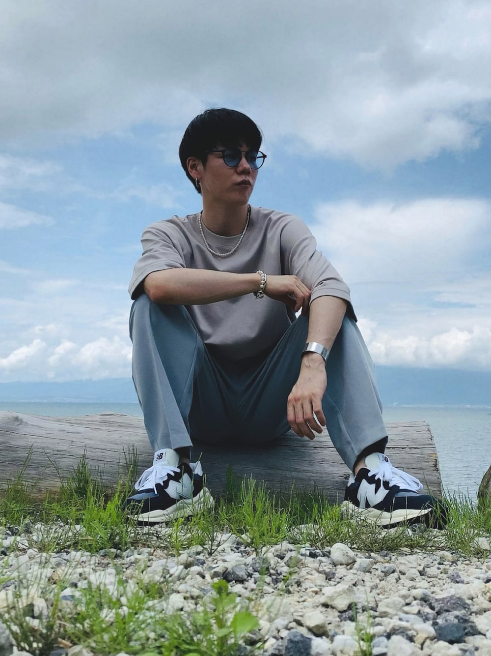 ブルー系のスニーカー、ブルー系のパンツ、グレー系のTシャツ/カットソーを着用したメンズの夏コーディネートの1枚目の写真