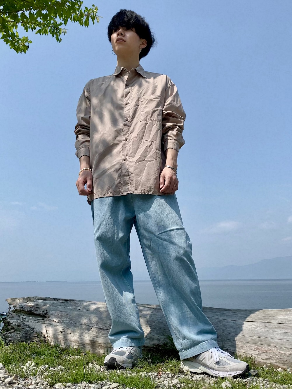 グレー系のスニーカー、ブルー系のデニムパンツ、ベージュ系のシャツ/ブラウスを着用したメンズの春コーディネートの1枚目の写真