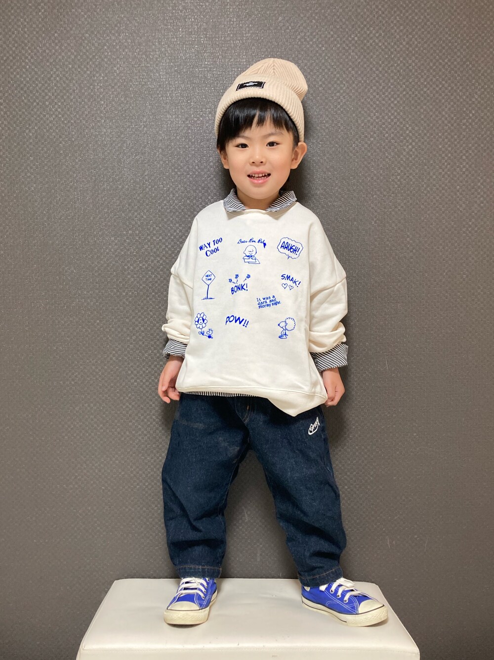 ホワイト系のスウェット、ブルー系のデニムパンツ、ブルー系のスニーカーを着用したキッズの冬コーディネートの1枚目の写真