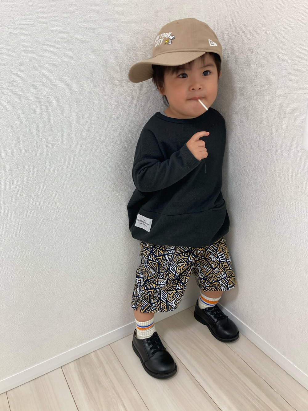 ブラック系のTシャツ/カットソー、オレンジ系のその他パンツ、ブラック系のドレスシューズを着用したキッズの春コーディネートの1枚目の写真