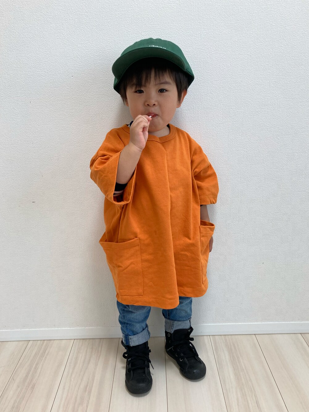 オレンジ系のTシャツ/カットソー、ブルー系のデニムパンツ、ブラック系のスニーカーを着用したキッズの春コーディネートの1枚目の写真