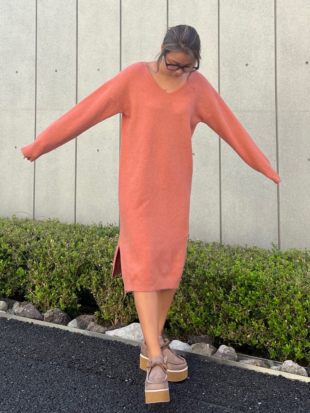 オレンジ系のワンピース、ベージュ系のモカシン/デッキシューズ、ブラック系のメガネを着用したレディースの秋コーディネートの1枚目の写真