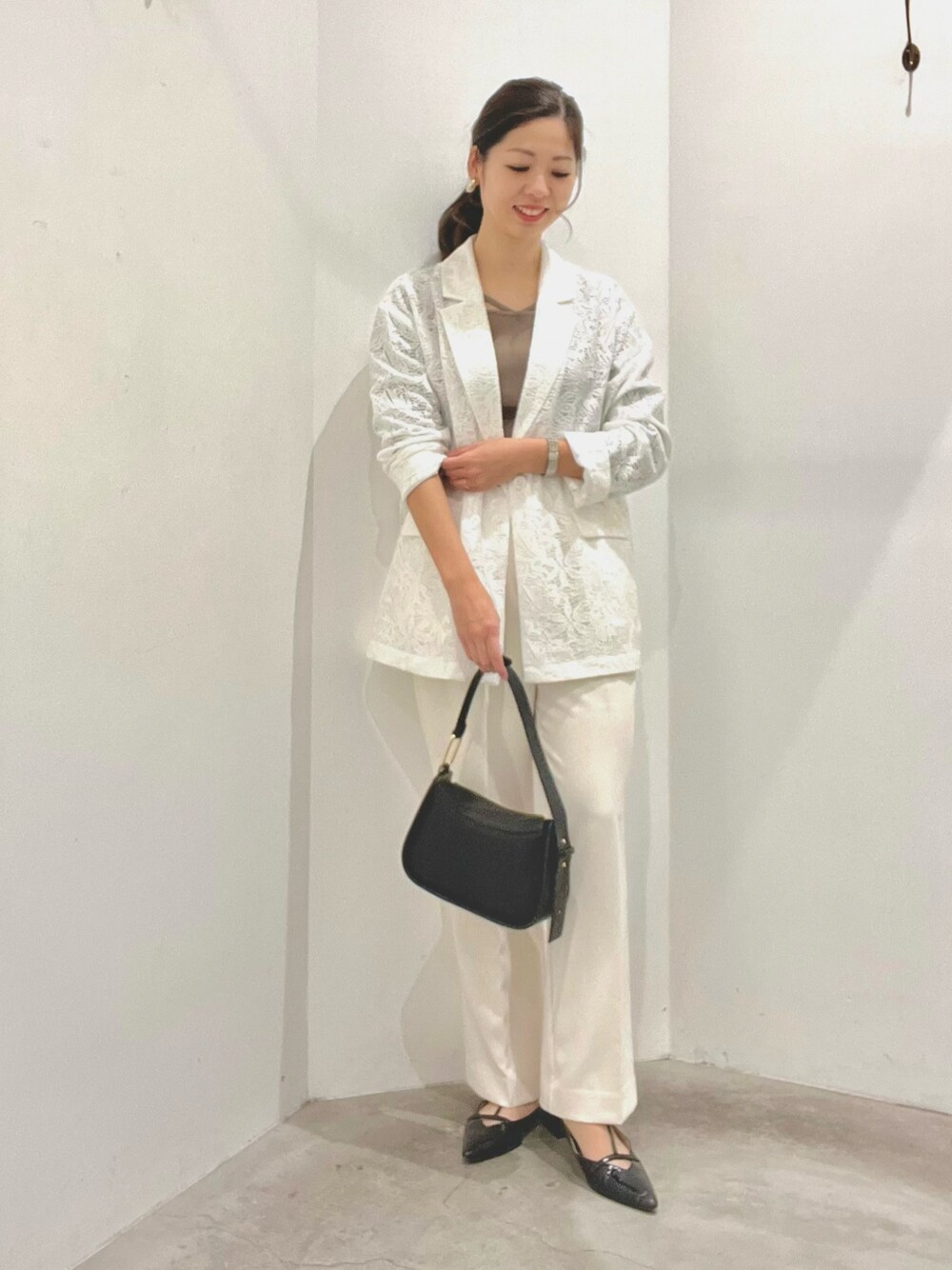 ホワイト系のテーラードジャケット、ベージュ系のニット/セーター、ホワイト系のその他パンツを着用したレディースの春コーディネートの1枚目の写真