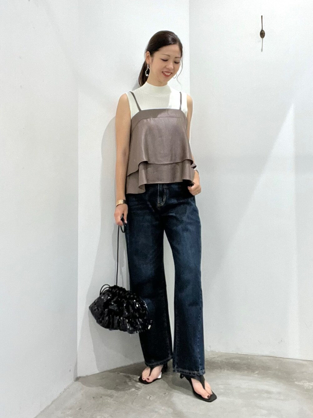 ブラウン系のキャミソール、ホワイト系のニット/セーター、ブルー系のデニムパンツを着用したレディースの夏コーディネートの1枚目の写真