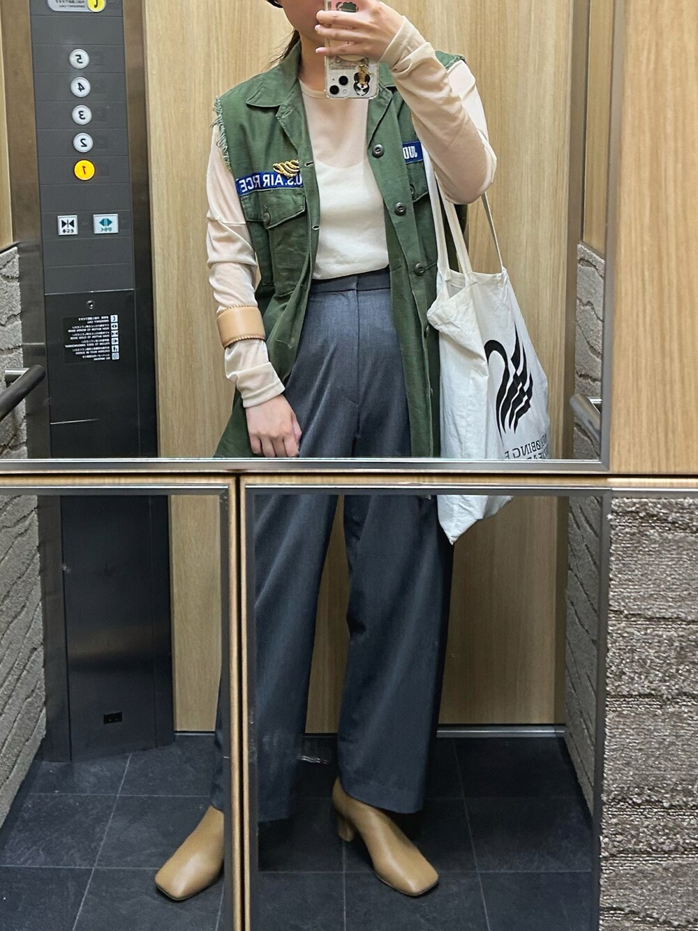 ベージュ系のTシャツ/カットソー、ベージュ系のブーツ、ベージュ系のバングル/リストバンドを着用したレディースの秋コーディネートの1枚目の写真