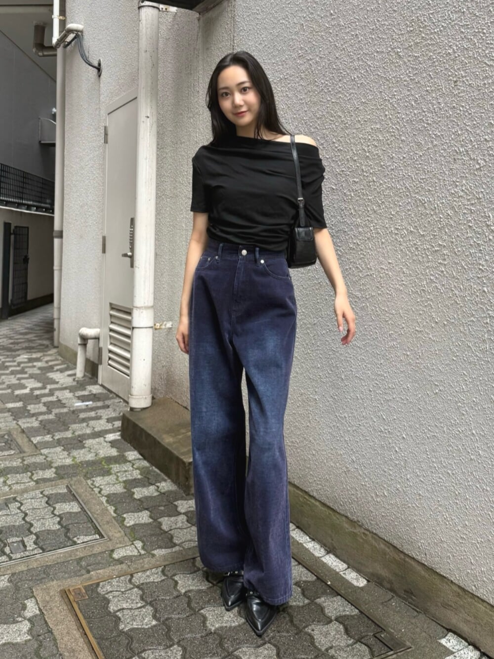 ブラック系のハンドバッグ、パープル系のデニムパンツ、ブラック系のパンプスを着用したレディースの夏コーディネートの1枚目の写真