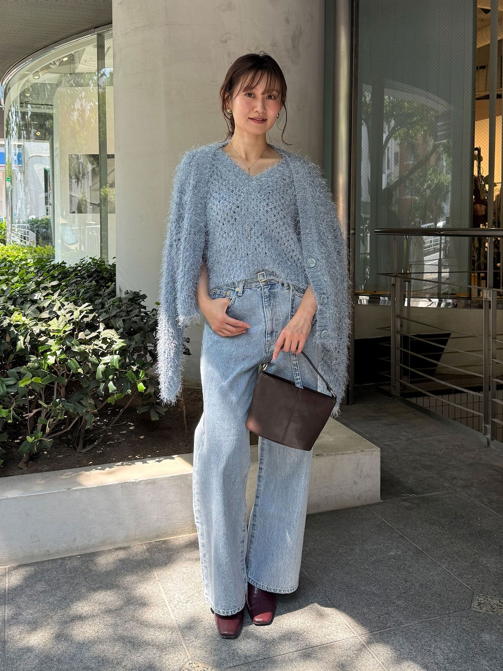 レッド系のブーツ、ブルー系のデニムパンツ、ブルー系のニット/セーターを着用したレディースの夏コーディネートの1枚目の写真