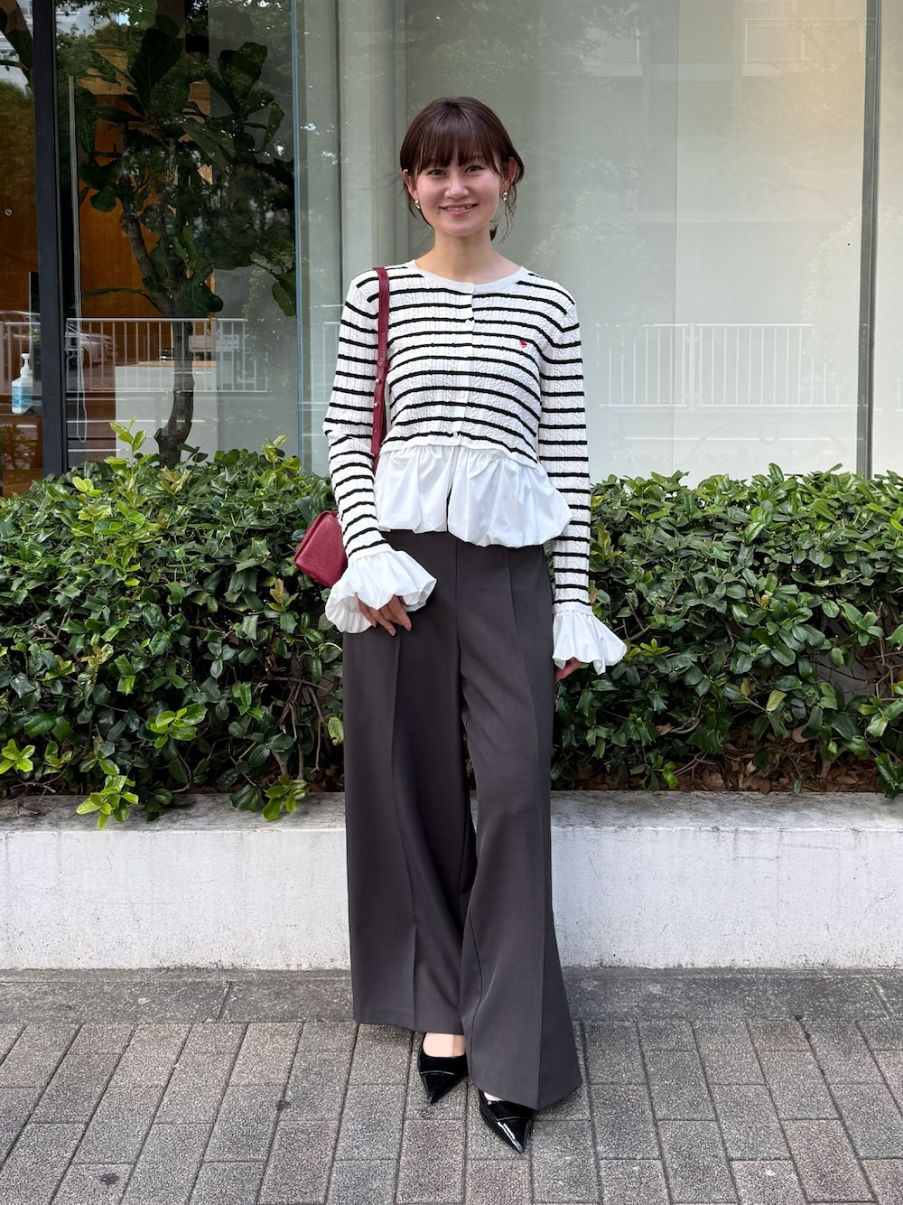 グレー系のその他パンツ、その他のカーディガン/ボレロ、レッド系のハンドバッグを着用したレディースの秋コーディネートの1枚目の写真
