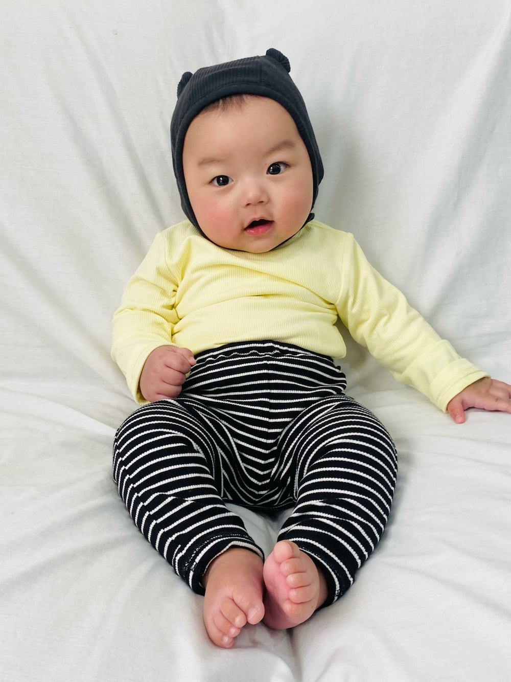 ブラック系のその他ベビーウェア、ブラック系のその他ベビーウェア、ホワイト系のロンパースを着用したキッズの冬コーディネートの1枚目の写真
