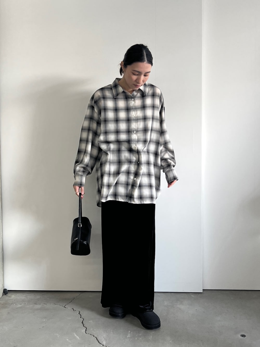 ホワイト系のシャツ/ブラウス、ブラック系のスカート、ブラック系のスリッポンを着用したレディースの冬コーディネートの1枚目の写真