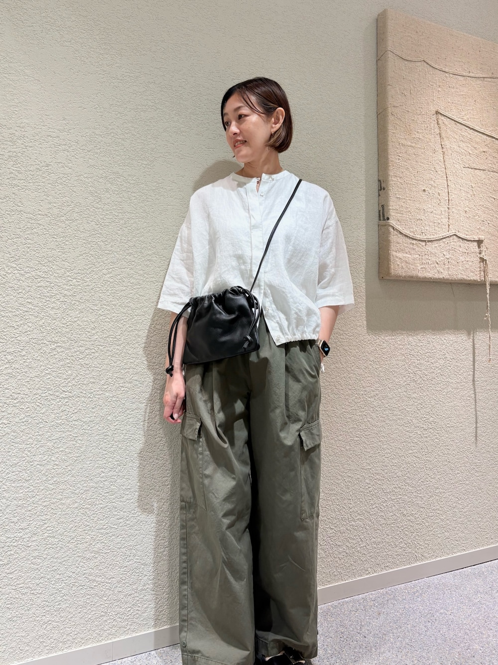 ホワイト系のシャツ/ブラウス、グリーン系のその他パンツ、ブラック系のショルダーバッグを着用したレディースの夏コーディネートの1枚目の写真