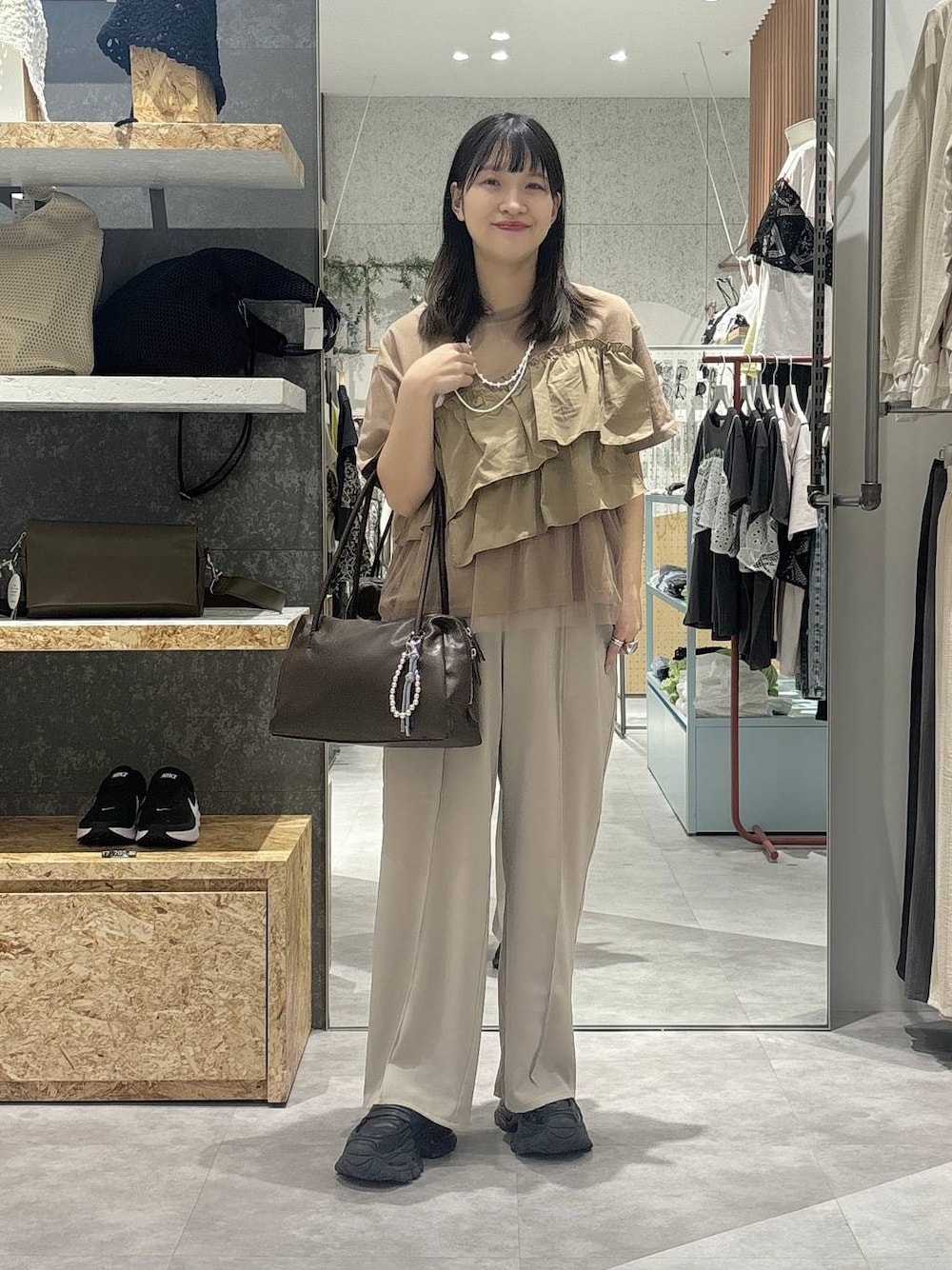 ブラウン系のボストンバッグ、ベージュ系のその他パンツ、ブラウン系のTシャツ/カットソーを着用したレディースの春コーディネートの1枚目の写真