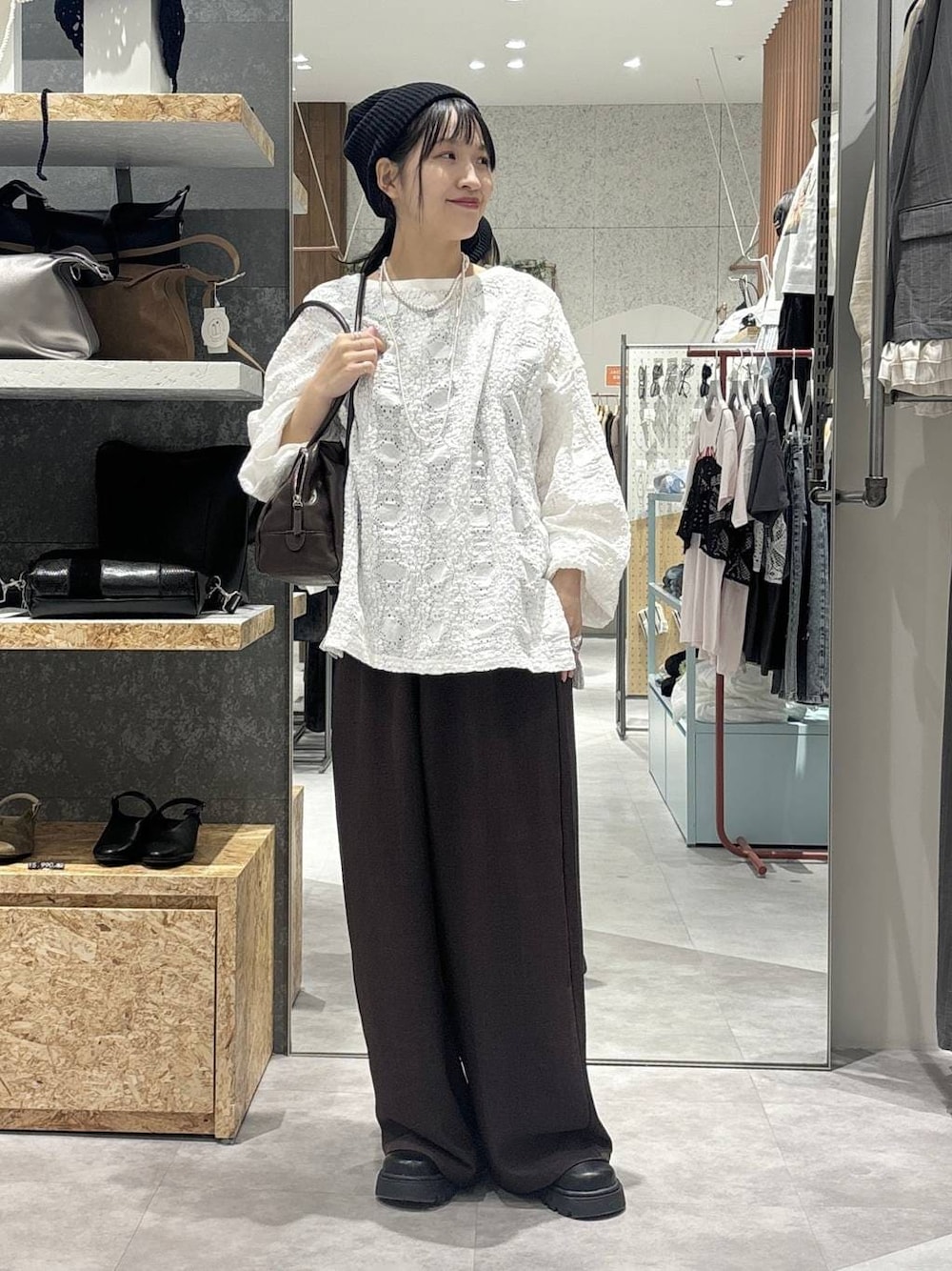 ブラック系のボストンバッグ、ブラック系のその他シューズ、ホワイト系のTシャツ/カットソーを着用したレディースの春コーディネートの1枚目の写真