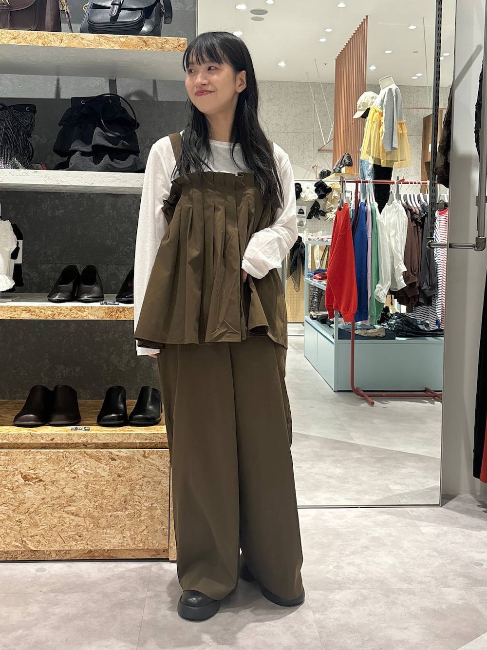 ブラック系のサンダル、ブラウン系のサロペット/オーバーオール、ホワイト系のTシャツ/カットソーを着用したレディースの秋コーディネートの1枚目の写真