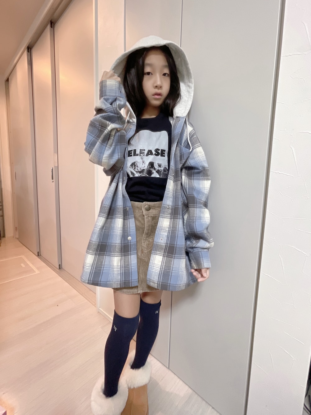 ブラック系のTシャツ/カットソー、ブルー系のその他アウター、ベージュ系のスカートを着用したキッズの秋コーディネートの1枚目の写真