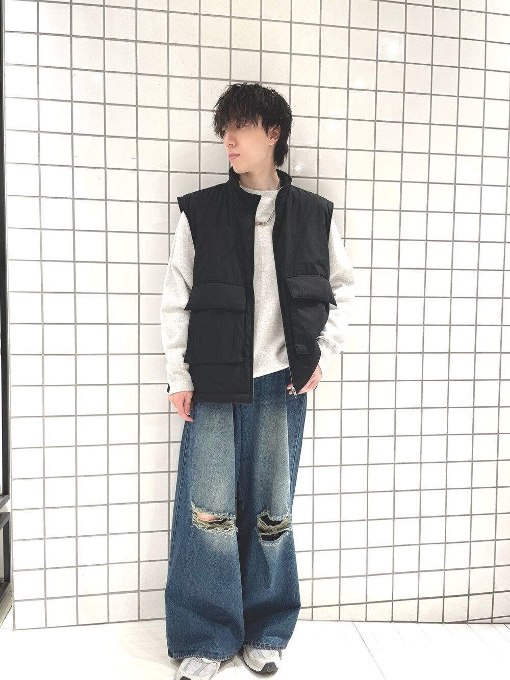 グレー系のスウェット、ブラック系のダウンベスト、ブルー系のデニムパンツを着用したメンズの冬コーディネートの1枚目の写真