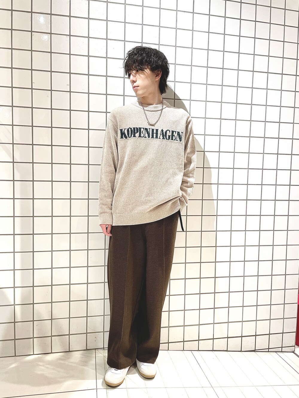 ベージュ系のニット/セーター、ブラウン系のその他パンツ、ホワイト系のスニーカーを着用したメンズの冬コーディネートの1枚目の写真