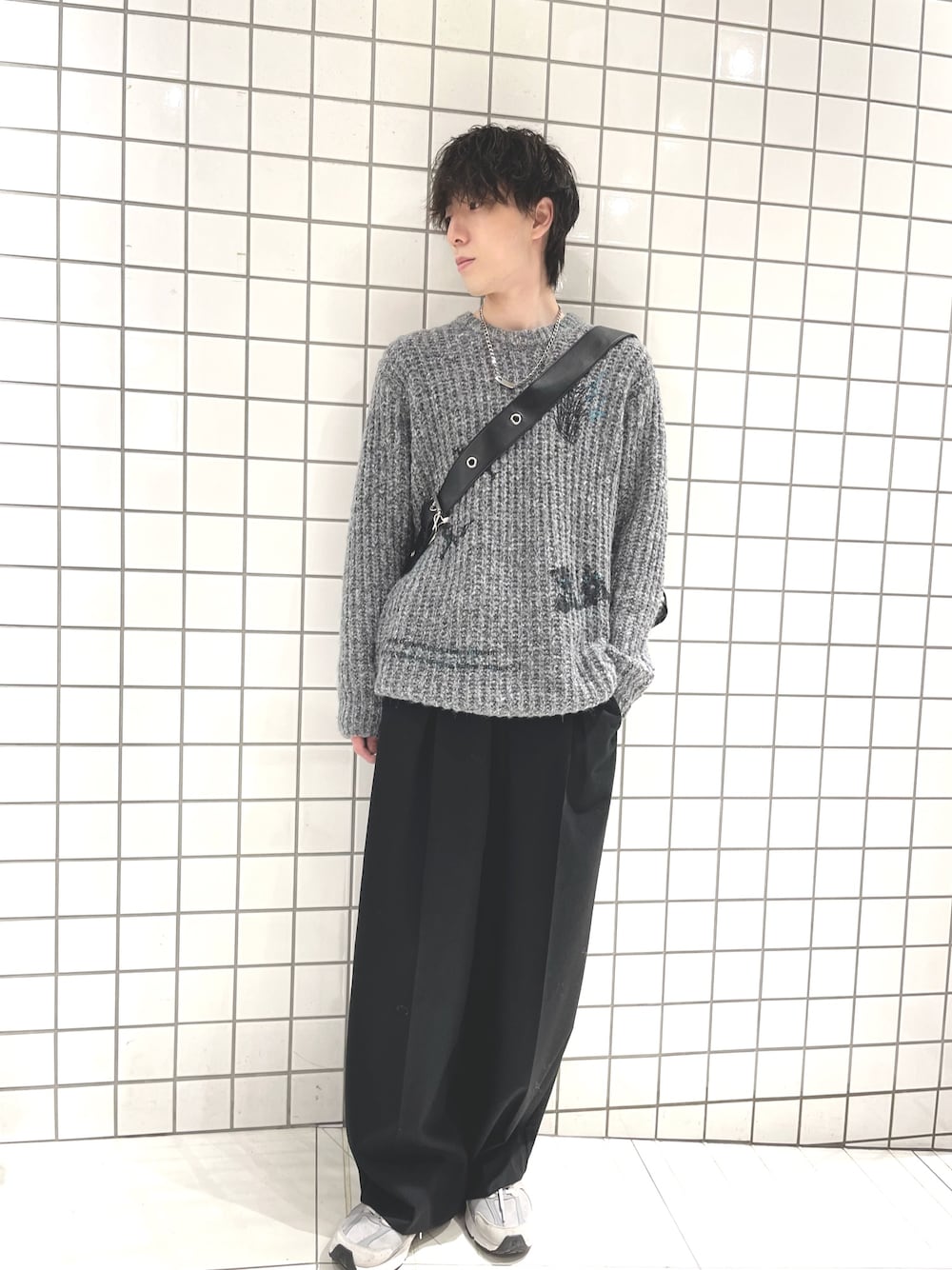 グレー系のニット/セーター、ブラック系のショルダーバッグを着用したメンズの冬コーディネートの1枚目の写真